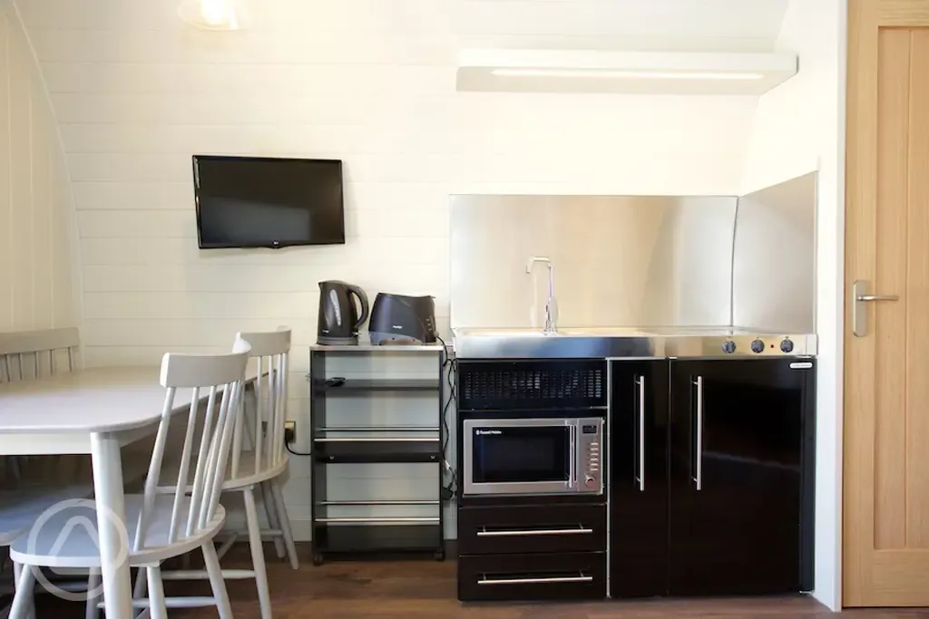 Superior pod kitchenette, dining table, and TV Superior pod kitchenette, dining table, and TV