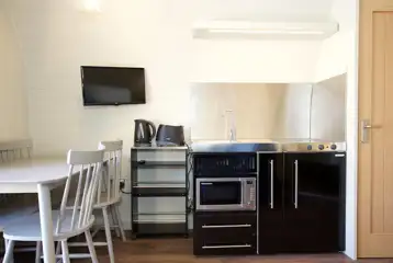 Superior pod kitchenette, dining table, and TV Superior pod kitchenette, dining table, and TV