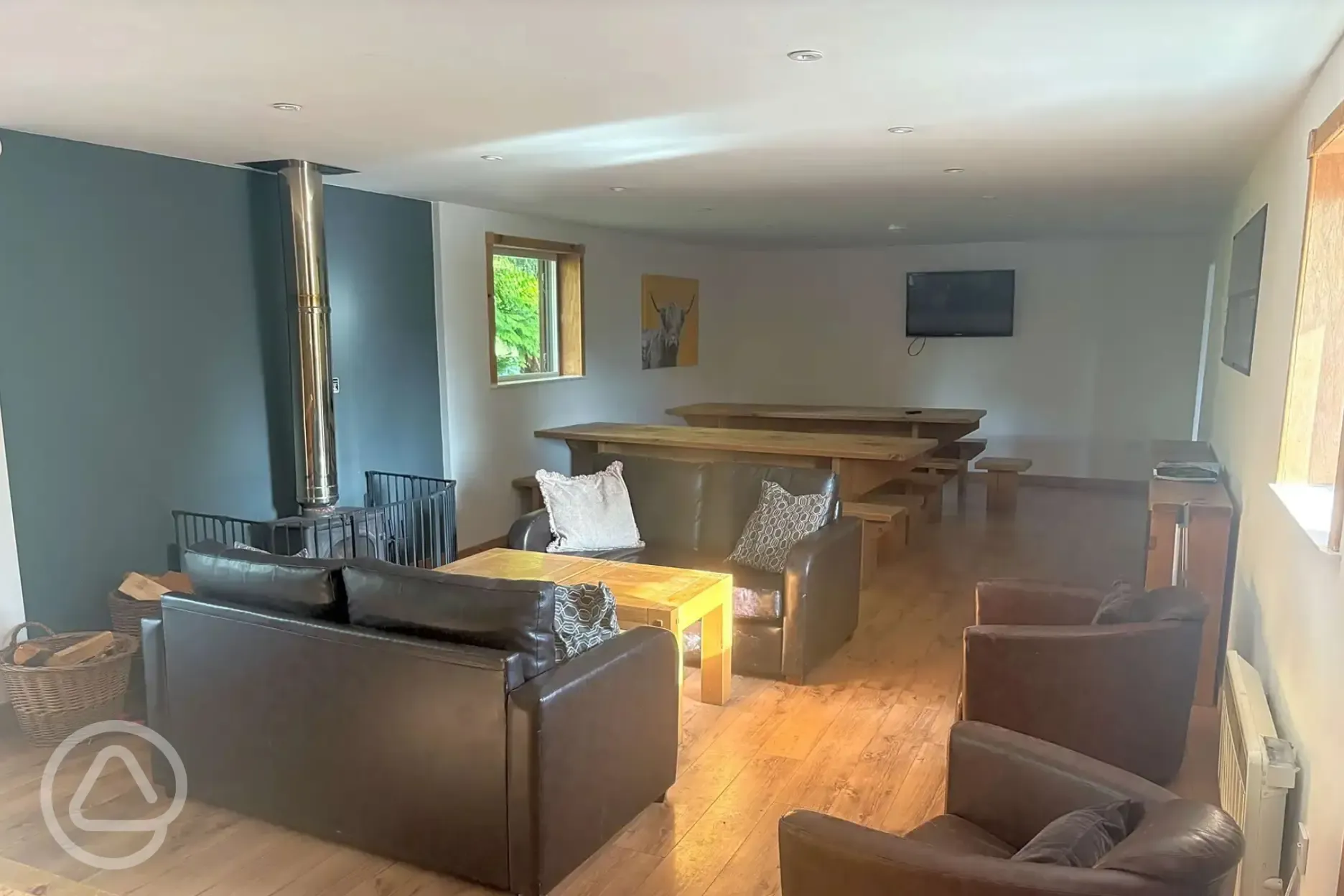 Communal area with tables, sofas, and a fire place Communal area with tables, sofas, and a fire place