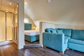 Superior ensuite glamping pod interior with double bed and sofa Superior ensuite glamping pod interior with double bed and sofa