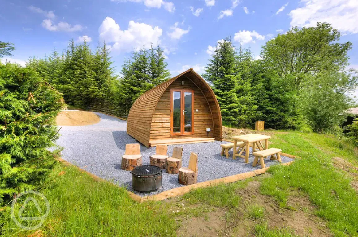 Premium ensuite glamping pods with picnic bench and wood carved stools Premium ensuite glamping pods with picnic bench and wood carved stools