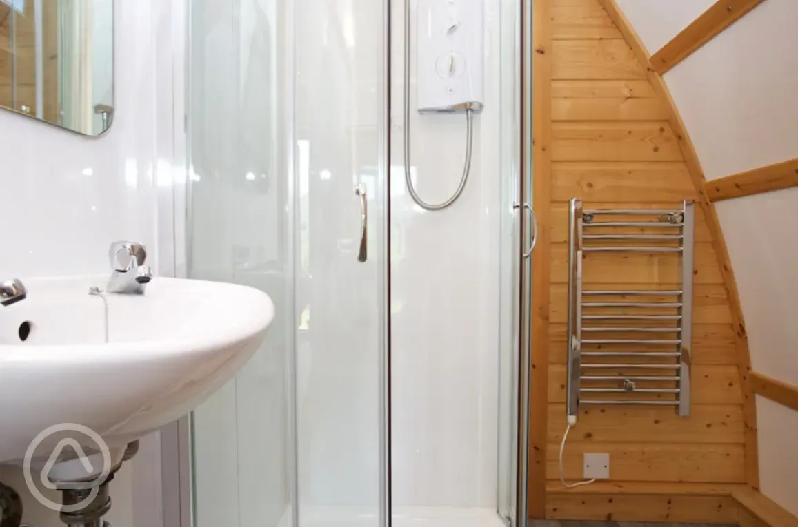 Premium ensuite glamping pod with a shower, heated towel rail, and sink Premium ensuite glamping pod with a shower, heated towel rail, and sink