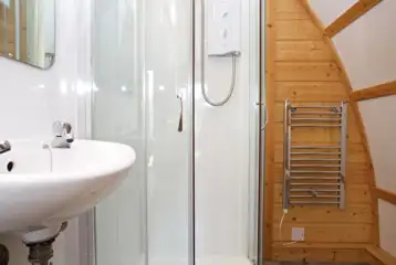 Premium ensuite glamping pod with a shower, heated towel rail, and sink Premium ensuite glamping pod with a shower, heated towel rail, and sink