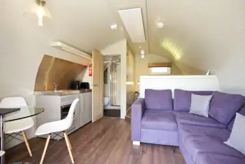Kitchen and sofa in the superior ensuite glamping pod Kitchen and sofa in the superior ensuite glamping pod