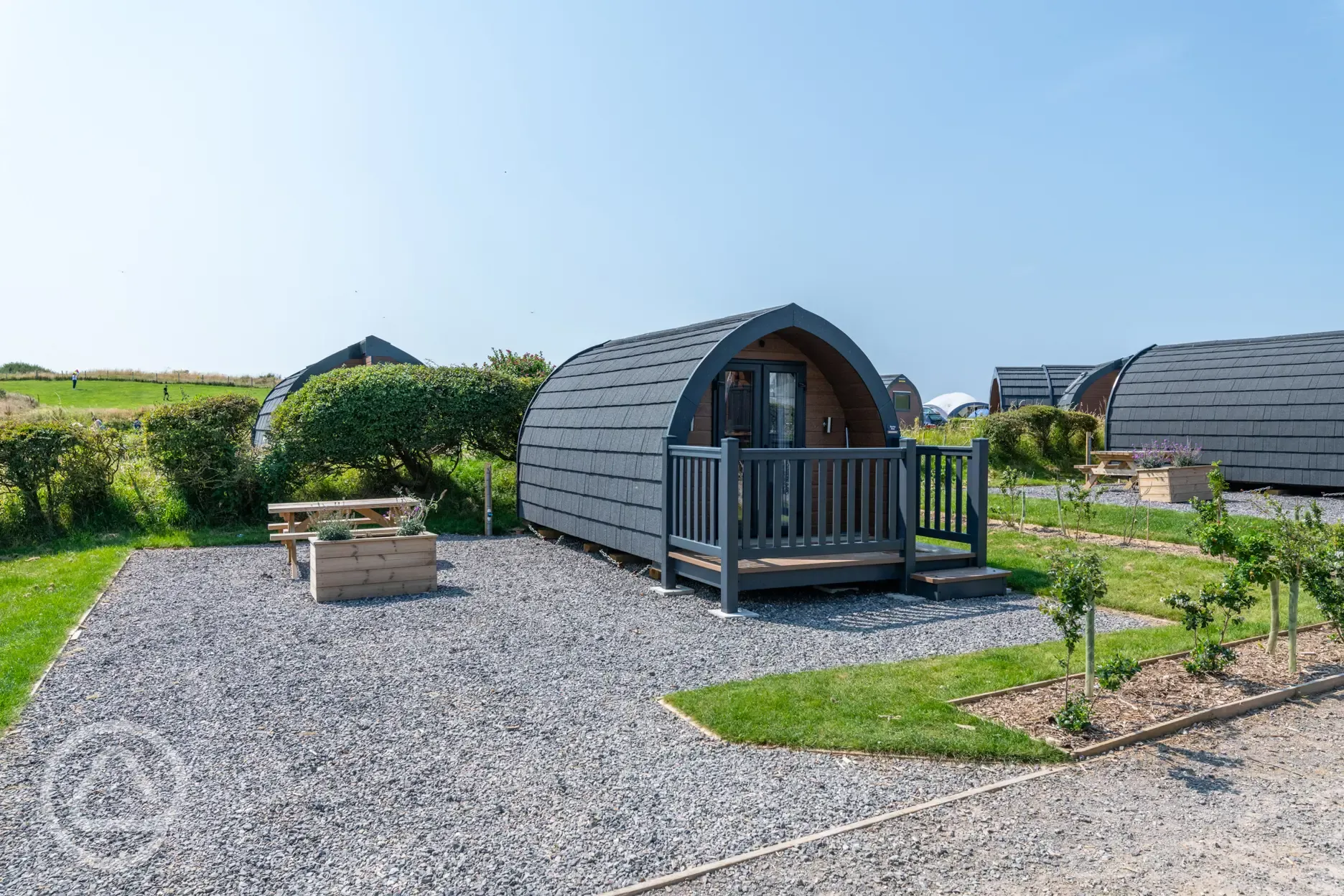 Bronze camping pod exterior with outdoor seating area, and sleeping up to four 