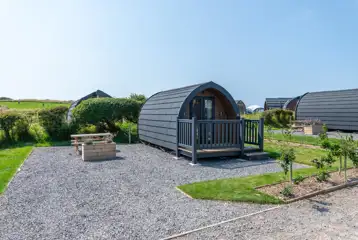 Bronze camping pod exterior with outdoor seating area, and sleeping up to four Bronze camping pod exterior with outdoor seating area, and sleeping up to four