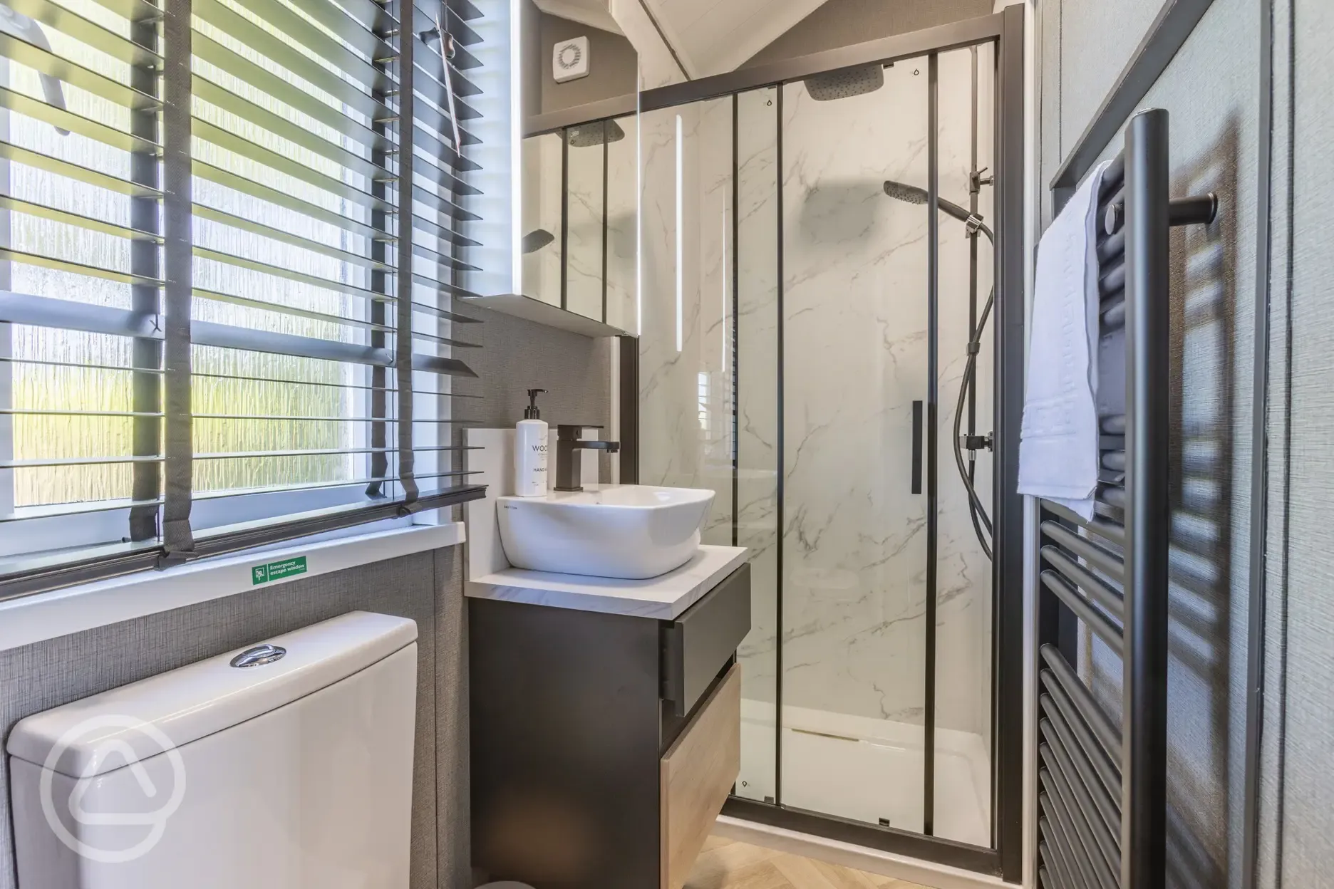 Ensuite glamping cabin bathroom with shower, toilet, sink and heated handrail