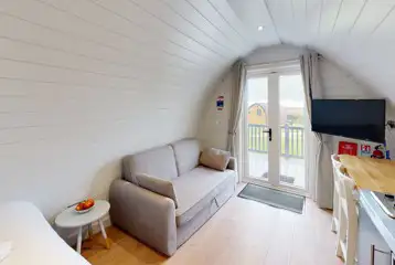 Glamping pod double sofa bed, dining area and TV