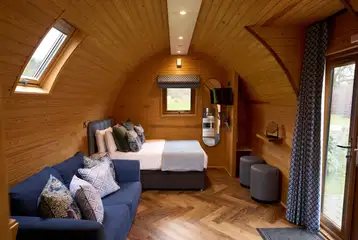 Kitchenette, sofa, and double bed in the deluxe mega pod (bedding provided) Kitchenette, sofa, and double bed in the deluxe mega pod (bedding provided)
