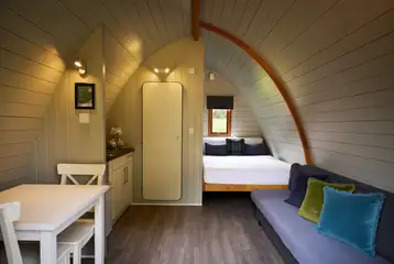 Premier glamping pod interior with a double bed and double sofa bed Premier glamping pod interior with a double bed and double sofa bed