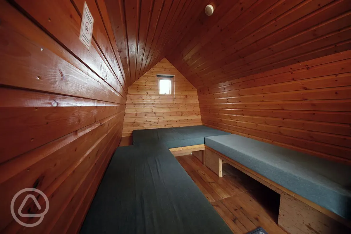 Camping pod interior with bench-style mattresses Camping pod interior with bench-style mattresses