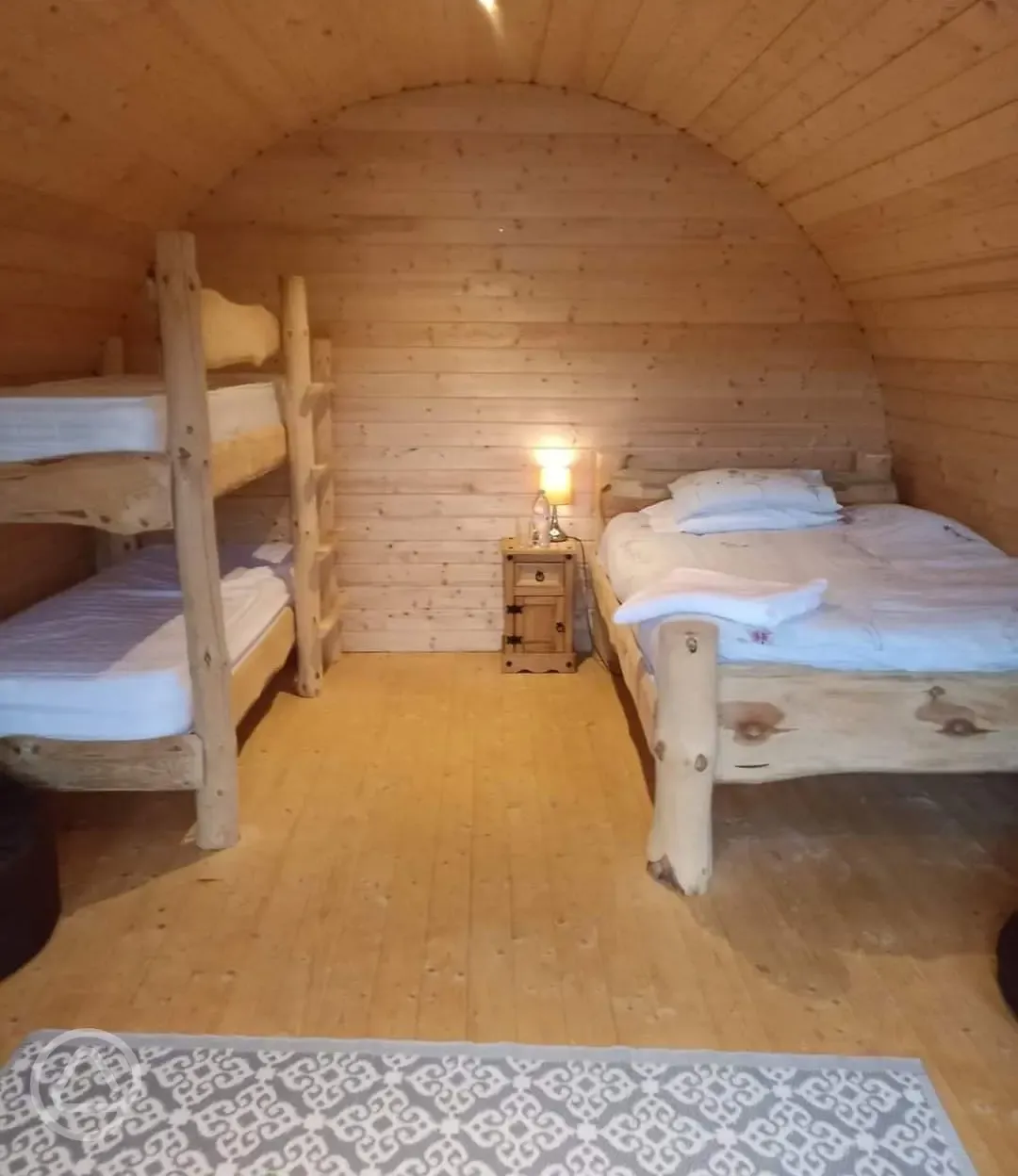 Family camping pod interior with a double bed and bunks (bring bedding)