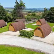 Aerial of the wooden camping pods with countryside views