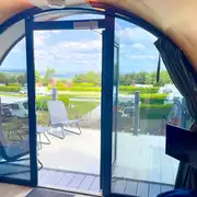 Super glamping pod with a glass front and decking with furniture