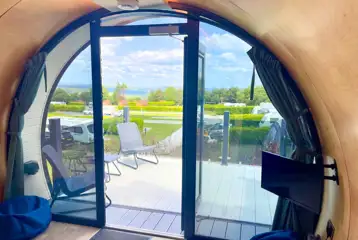 Super glamping pod with a glass front and decking with furniture