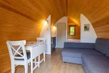 Mega pod interior with a futon sofa, TV, dining area, and ensuite toilet Mega pod interior with a futon sofa, TV, dining area, and ensuite toilet