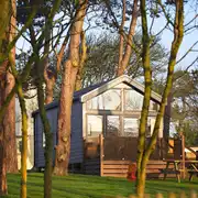 Skylight glamping cabins with glass fronts and decking areas