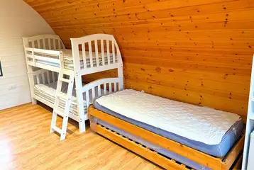 Six person camping pod interior with bunk beds and two singles