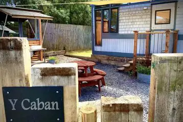 Y Caban garden area with a picnic bench and outdoor kitchen Y Caban garden area with a picnic bench and outdoor kitchen