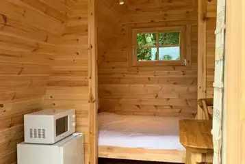Small pod interior with a double bed, fridge and microwave Small pod interior with a double bed, fridge and microwave