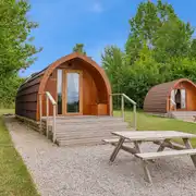 Deluxe Mega Pod exterior with stairs and a picnic bench Deluxe Mega Pod exterior with stairs and a picnic bench