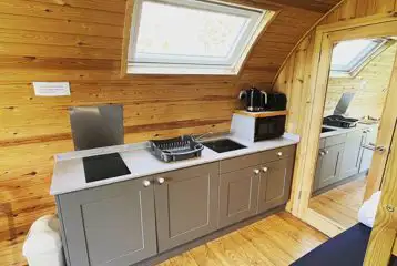 Deluxe Mega Pod large kitchen with a hob, microwave, toaster, and sinks Deluxe Mega Pod large kitchen with a hob, microwave, toaster, and sinks