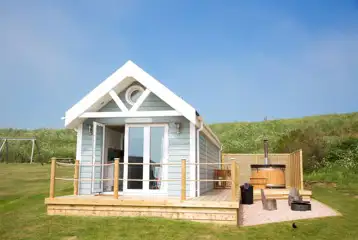 Deluxe ensuite beach hut with a wood-fired hot tub, fire pit and seating