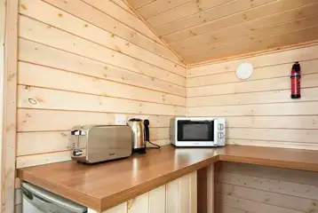 Standard beach hut kitchen area with toaster, kettle, microwave, and fridge