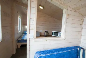 Standard beach hut interior with twin beds and a small kitchen area