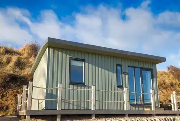 Standard beach hut with an outdoor deck and picnic bench