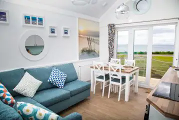 Deluxe beach hut with a double sofa bed and dining area