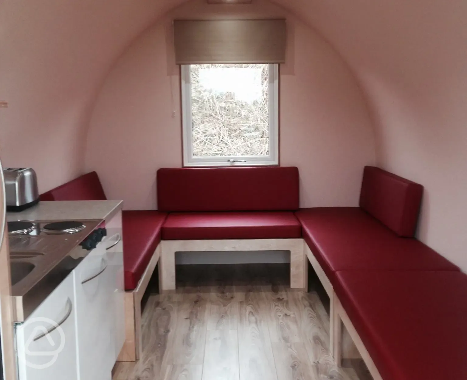 Camping pod interior with seating area that doubles as sleeping platforms