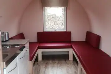 Camping pod interior with seating area that doubles as sleeping platforms Camping pod interior with seating area that doubles as sleeping platforms