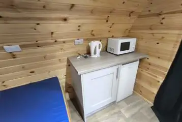 Ensuite pod kitchen area with a mini fridge, microwave and kettle