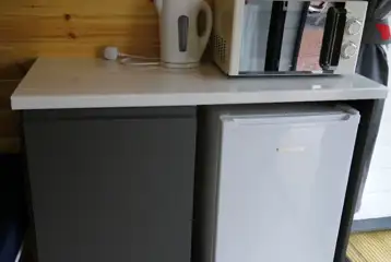 Ensuite pod kitchen area with a mini fridge, microwave and kettle