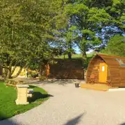 Camping pods with surrounding trees and picnic benches Camping pods with surrounding trees and picnic benches