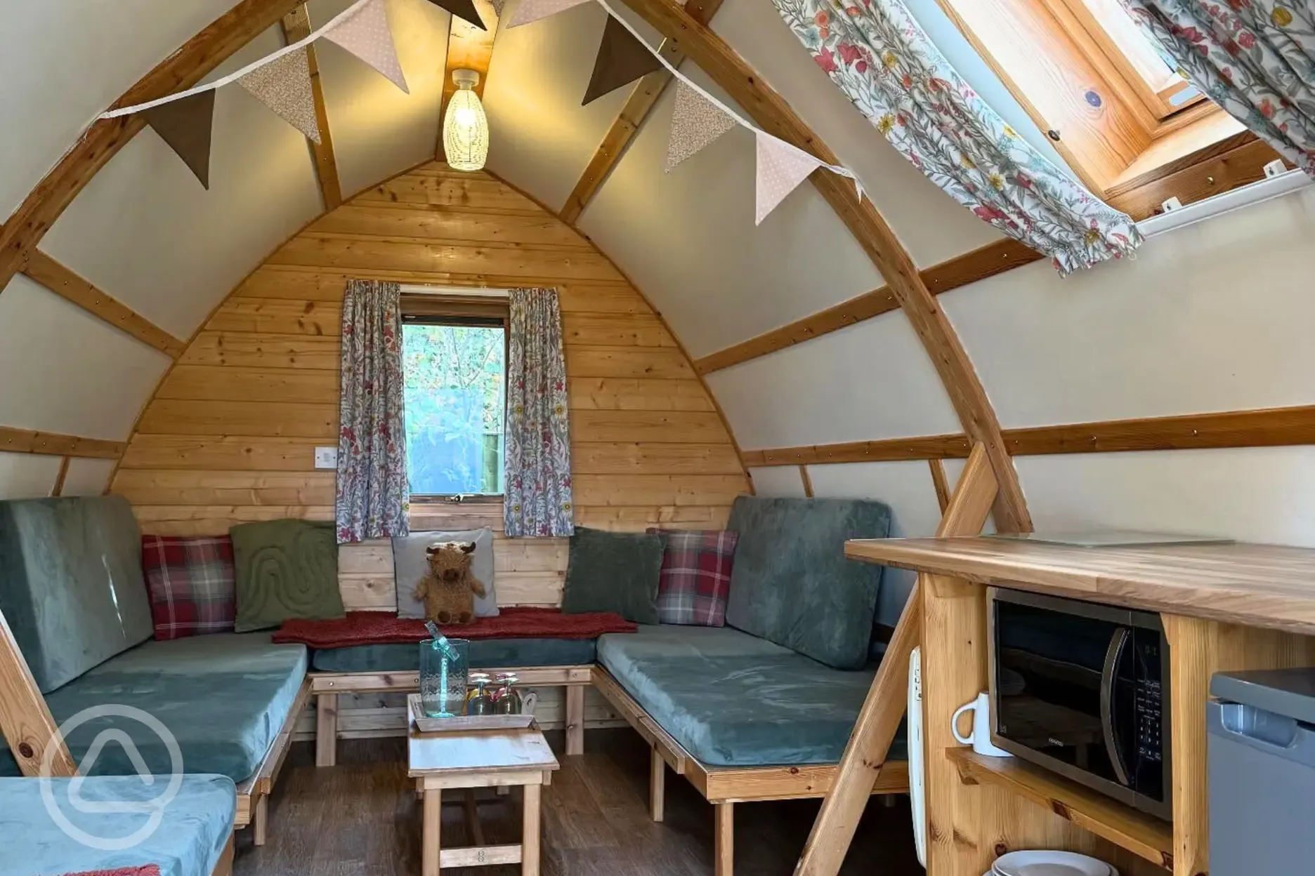 Camping pod interior with sofas and a small kitchenette