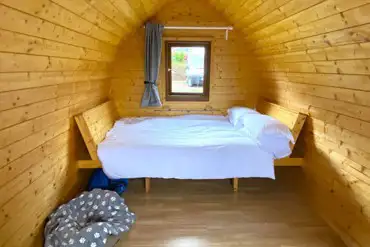 Log pod interior with bed made-up