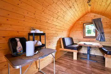 Log pod interior with chairs that convert to a double bed