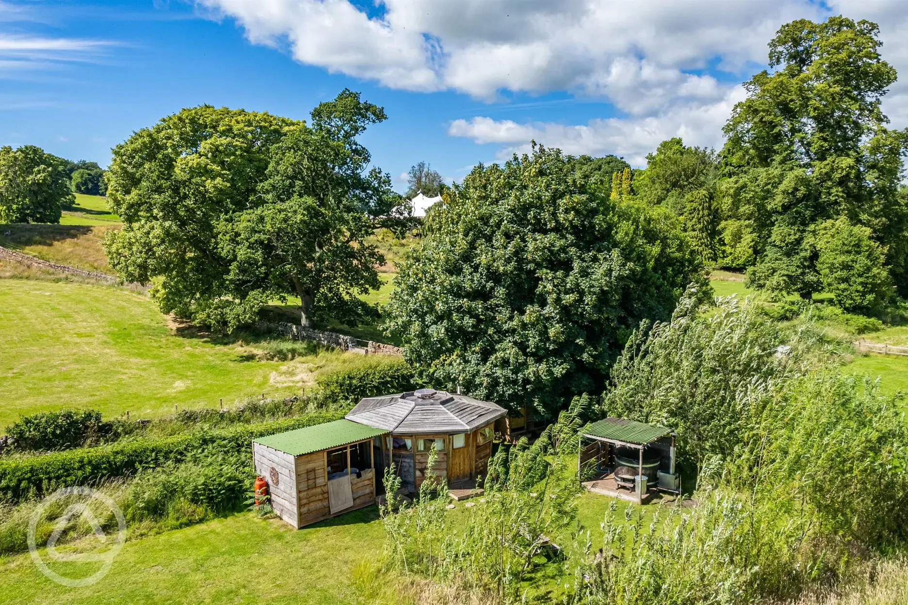 Aerial of a wooden cabin with a sheltered kitchen and hot tub