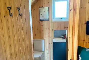 Pod ensuite bathroom with toilet, sink, shower and towels