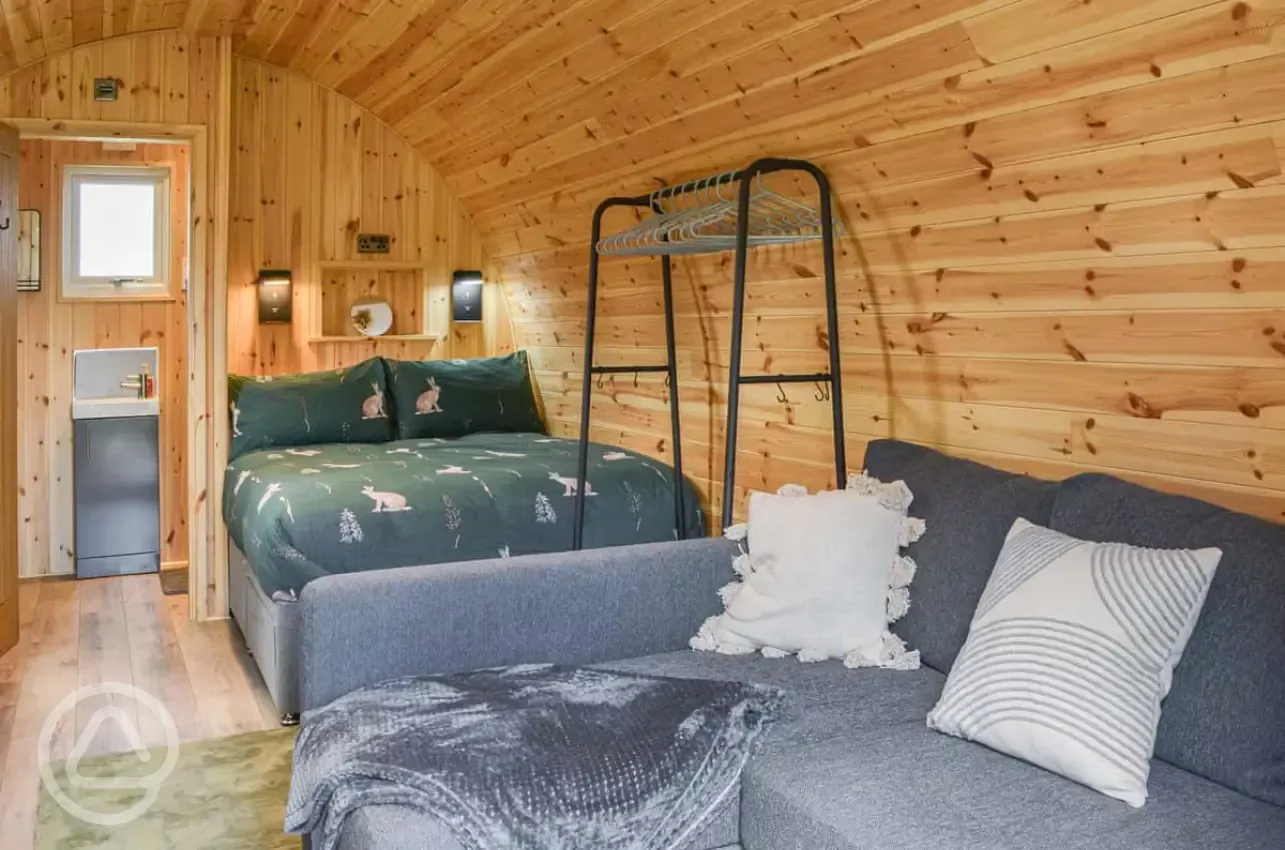 Glamping pod interior with a double bed and double sofa bed (bedding included)