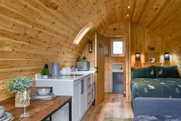 Ensuite glamping pod interior with a double bed and double sofa bed Ensuite glamping pod interior with a double bed and double sofa bed