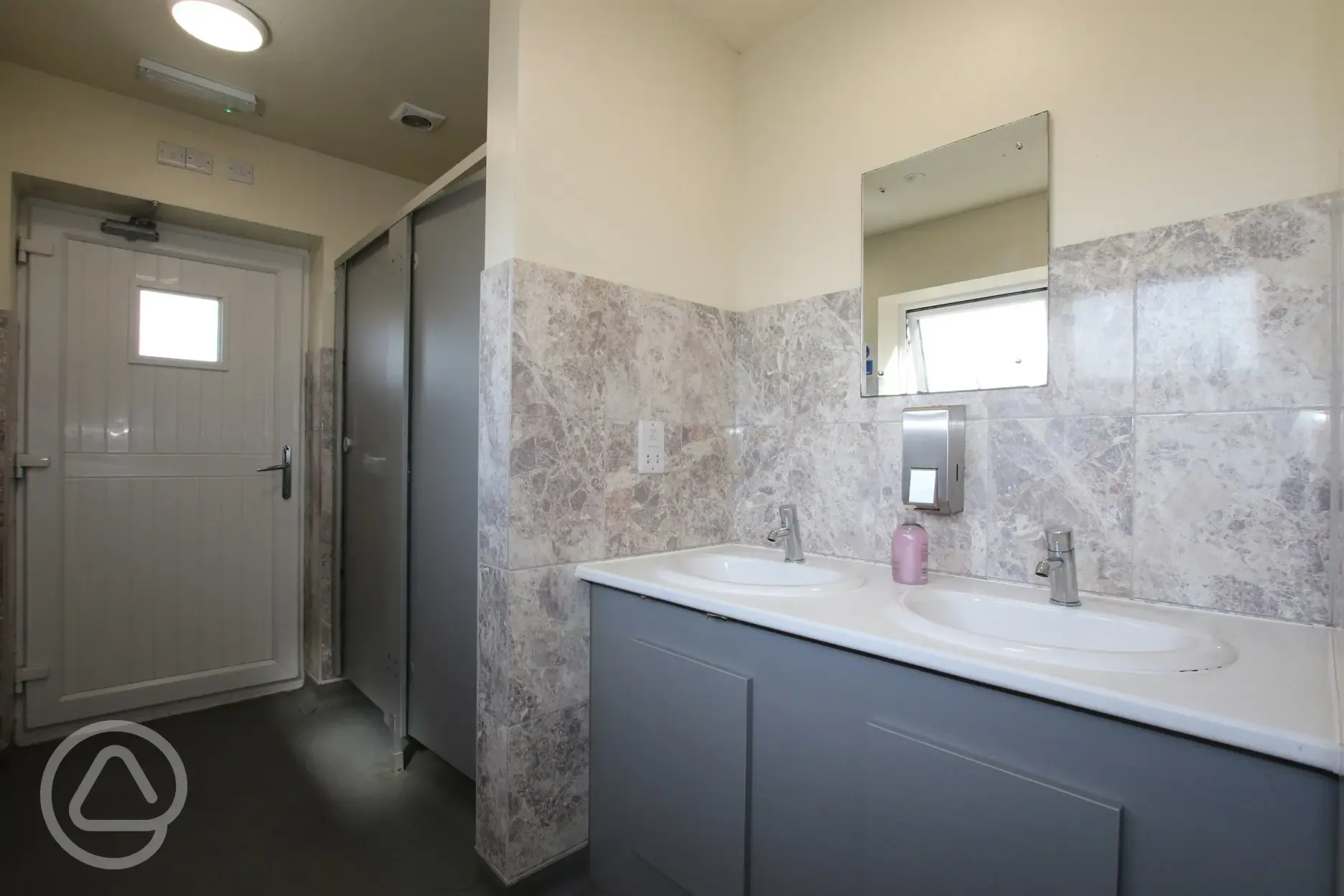 Facilities interior with cubicles, sinks and mirrors