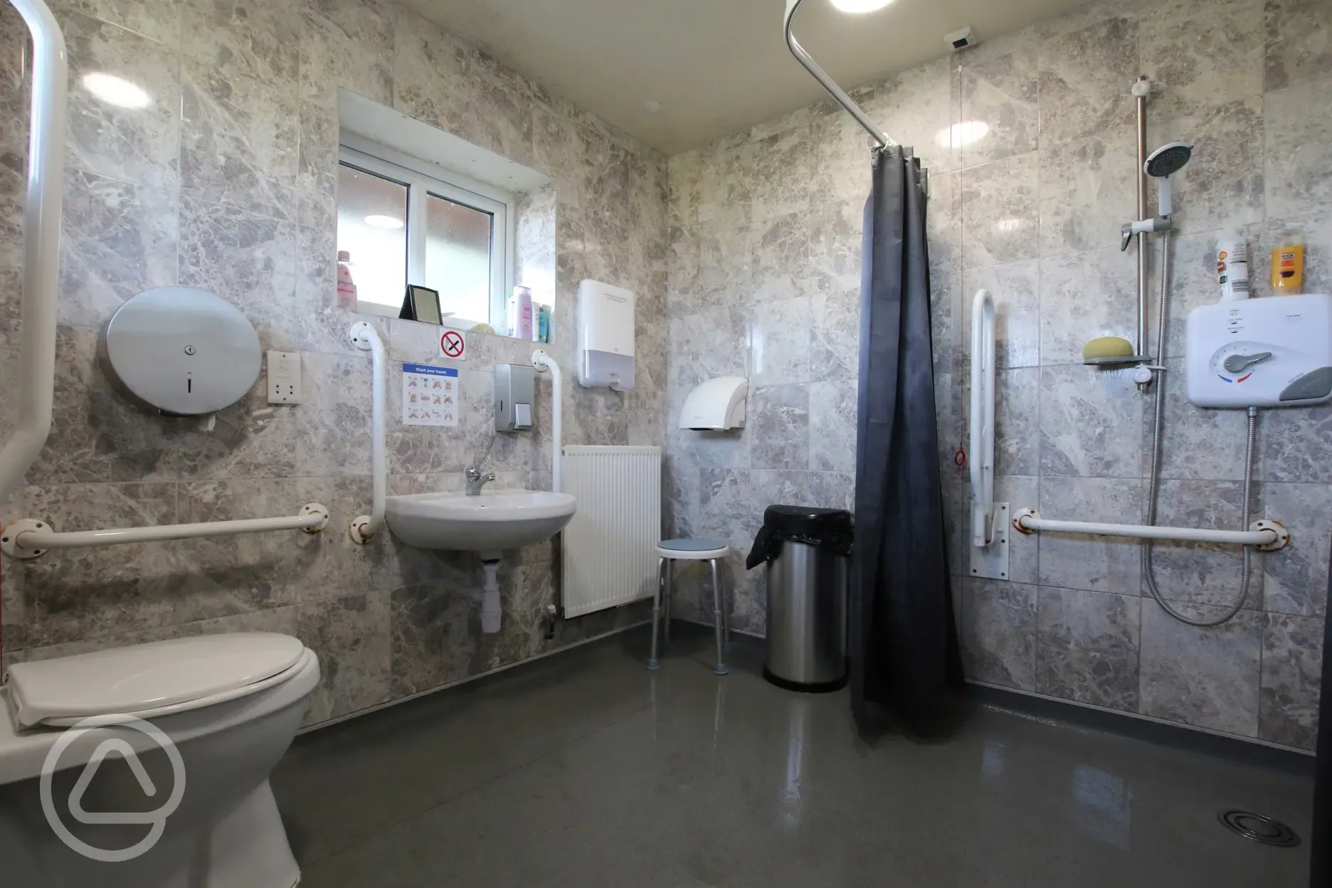 Disabled toilet and shower with handrails and sink