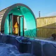 Deluxe pod exterior with hot tub and fire pit