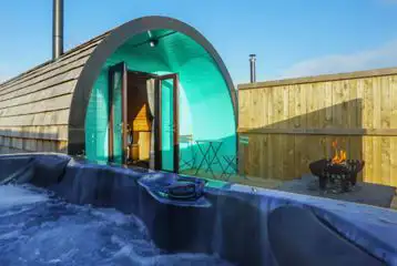Deluxe pod exterior with hot tub and fire pit