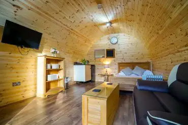 Original pod interior with double bed, TV and living space