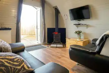Deluxe pod interior living space with tv and sofas