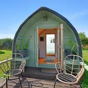 Sweet Pea camping pod exterior with an outdoor deck and seating Sweet Pea camping pod exterior with an outdoor deck and seating